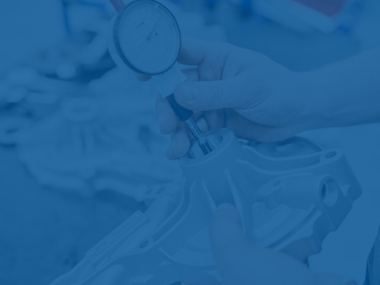 Close-up of a hand checking a spare part with a measuring tool