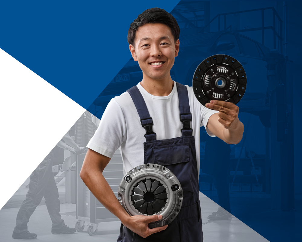 Mechanic holding a clutch disc and a pressure plate in each hand