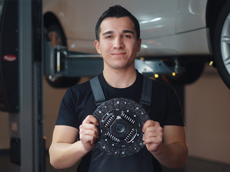 Two mechanics in the workshop, bent over the components of a clutch